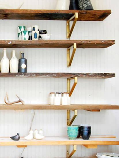 Chic Ikea Hacks - These gold brackets with paired with reclaimed wood shelves make a stunning wall shelving unit 