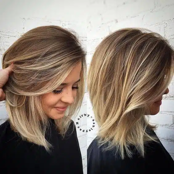Medium length lob cut hair with layers and balayage highlights. 