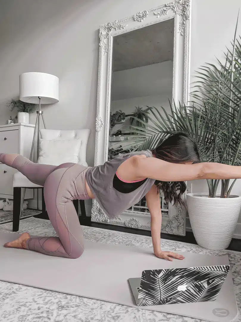 Doing pilates in Lululemon workout outfit with leggings and top.
