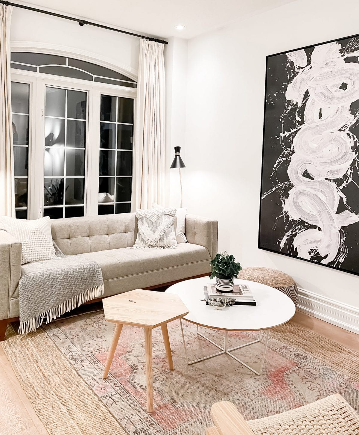 5 valuable tips for home buying. This is a beautiful living room with a modern mid-century sofa, contemporary artwork and scandinavian furnishings.  