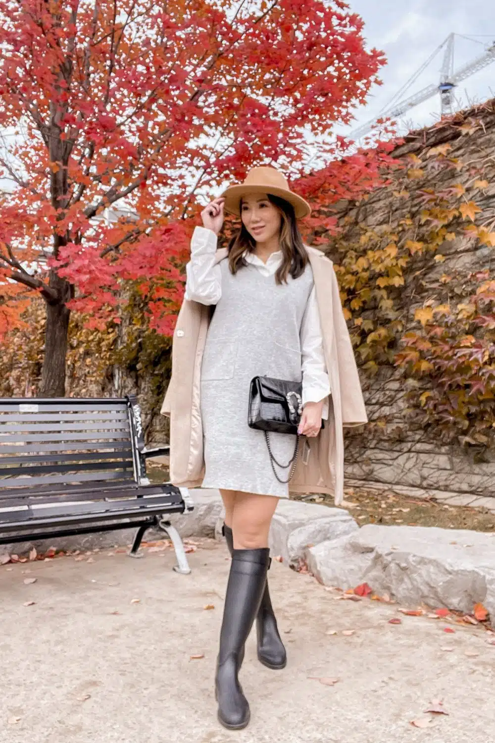 Fall outfit with sweater vest dress over a white shirt, brown coat and riding boots. Get more outfit ideas and fashion inspiration at yesmissy.com
