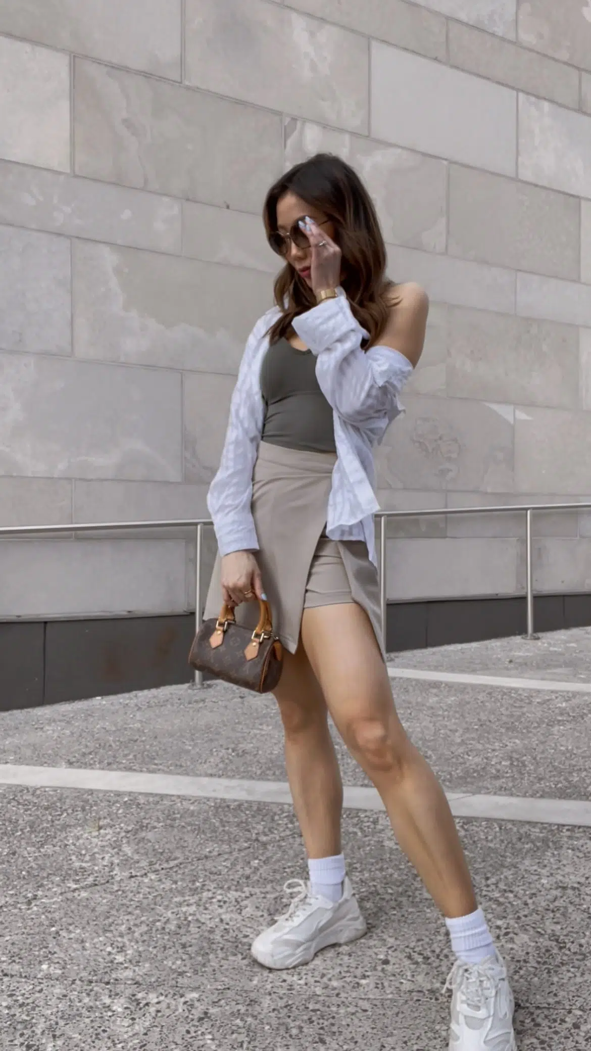 Casual summer fit with skort, tank top and button down shirt with sneakers and mini bag. Outfit details on yesmissy.com