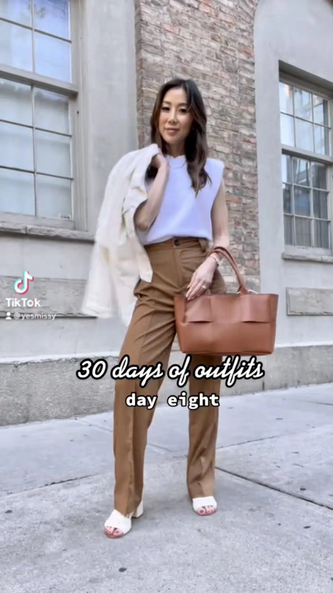 Neutral workwear outfit with brown trousers, knit shoulder pad tee fr CHRLDR and leather mule sandals fr ketchshoes, bag from Jeanne Lottie . Styled by Toronto fashion blogger Eileen Lazazzera of yesmissy.com