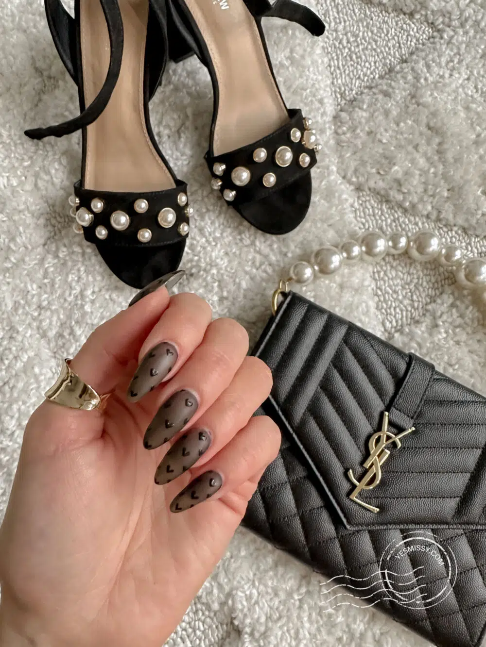 Luxury details - black heart nails, black sandals with pearls, Saint Laurent envelope clutch converted into a handbag.