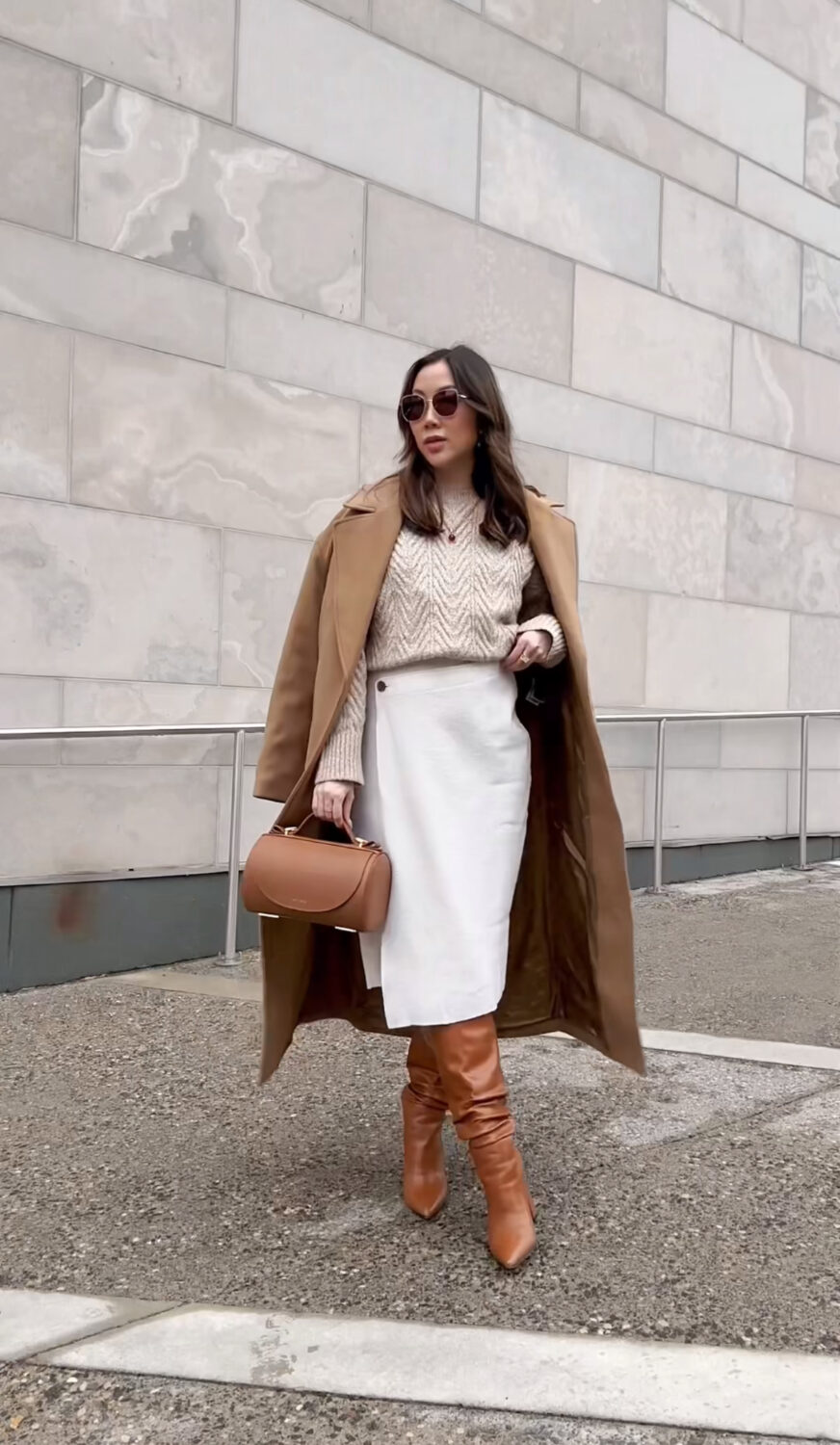 Classy winter outfit idea - Neutral look with cable knit sweater, knit wrap dress, and tan wool coat from Banana Republic. Accessorized with tall brow boots, Senreve barrel bag and Jewelry from Dean Davidson