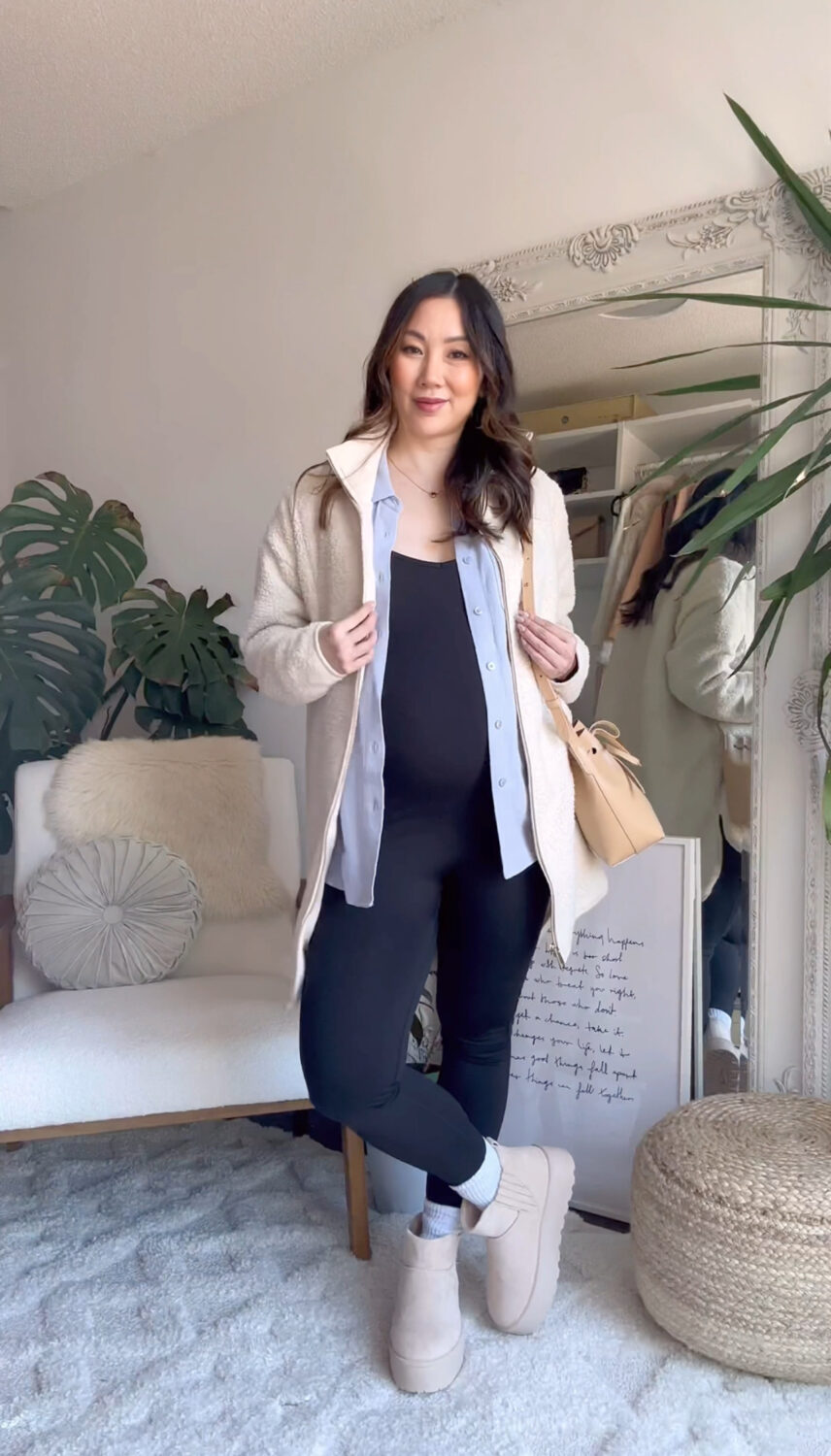 Casual maternity look with black jumpsuit button down shirt and sherpa jacket accessories with bucket bag and Platform Ugg boots