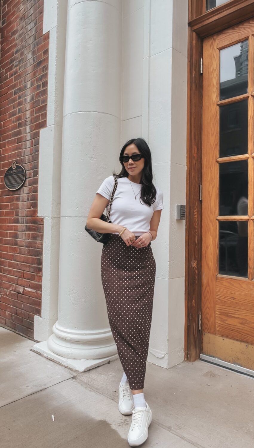 Spring capsule wardrobe outfit: polka dot midi skirt, white tee, knit sweater and minimal sneakers