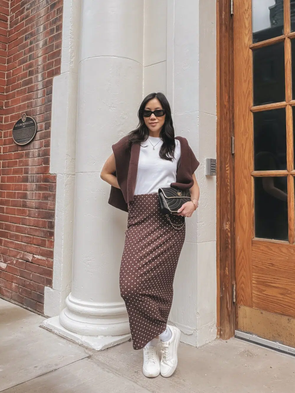 Effortless spring outfit with a brown and white polka dot maxi skirt and tonal layering